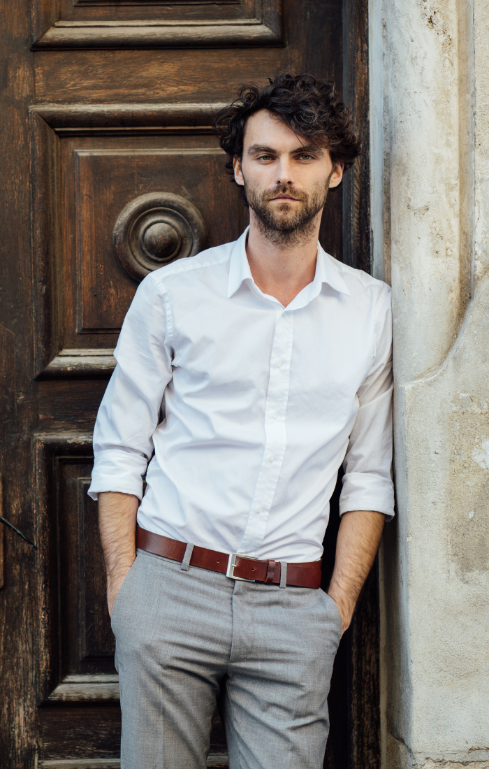 Dressing in white shirt, a black tie, gray pants and leather shoes, a young  handsome black college student is standing by a stone wall, confidently lo  Stock Photo - Alamy